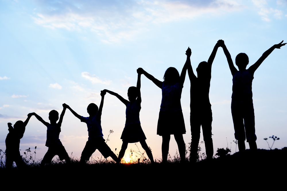 Children silhouettes holding hands up