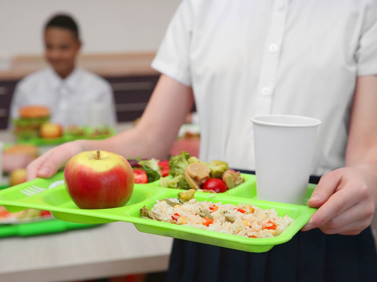 Schoolchild carrying school dinner tray
