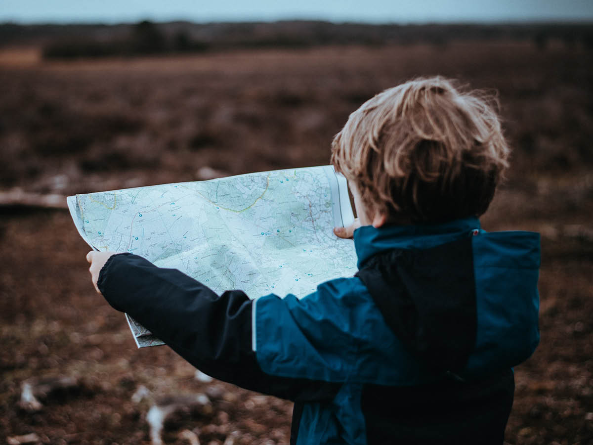 Child with large map facing away from camera